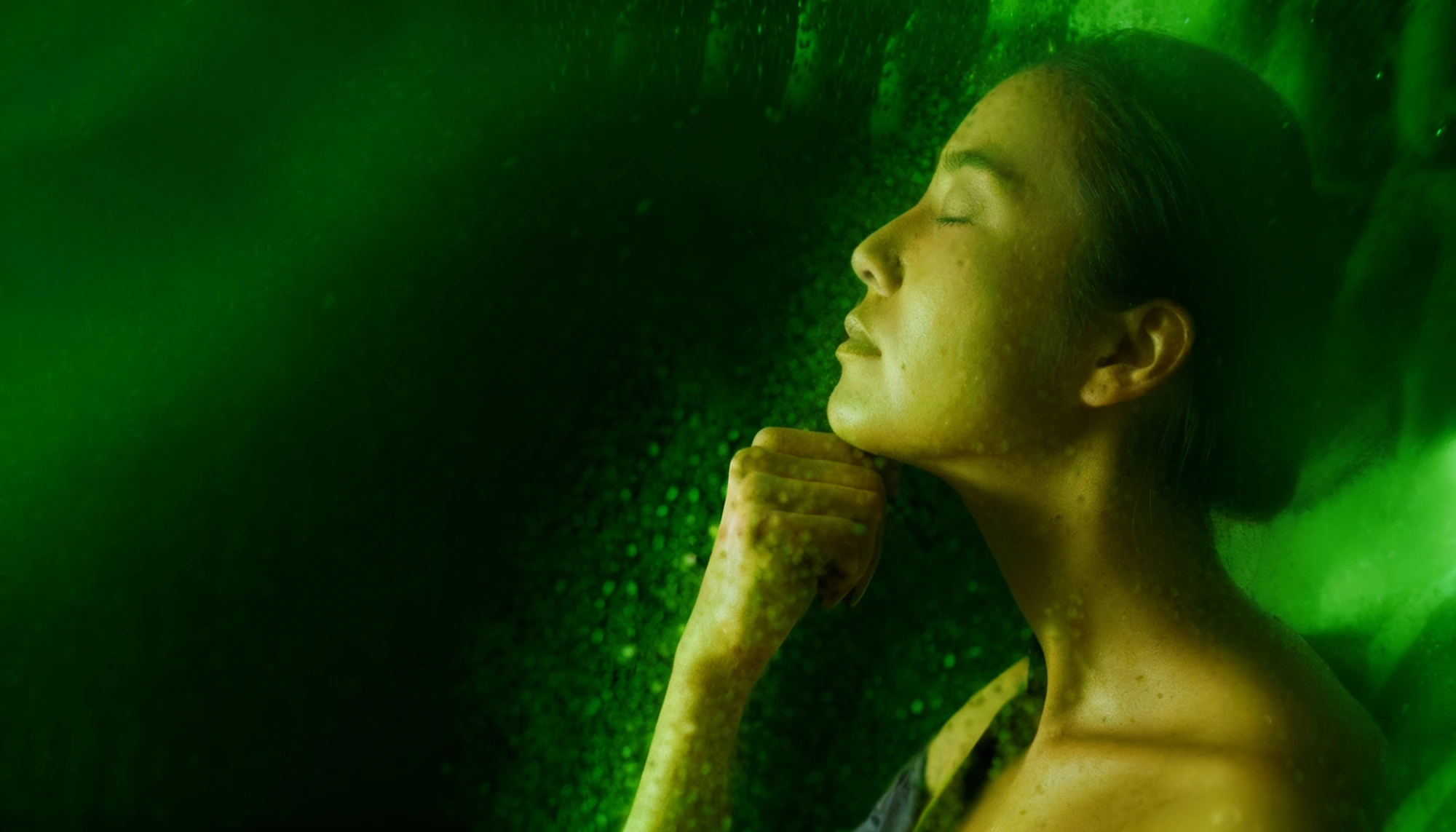 A woman looking thoughtfully towards the sunset over the sea.